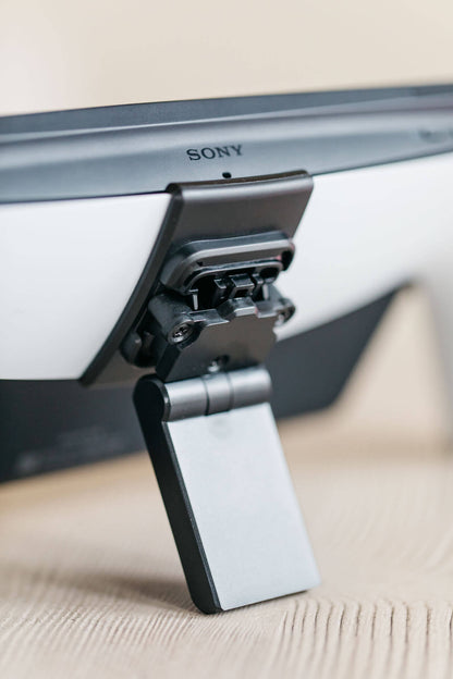 A Playstation Portal propped up on a Mechanism Kickstand using the Portalmate Grip