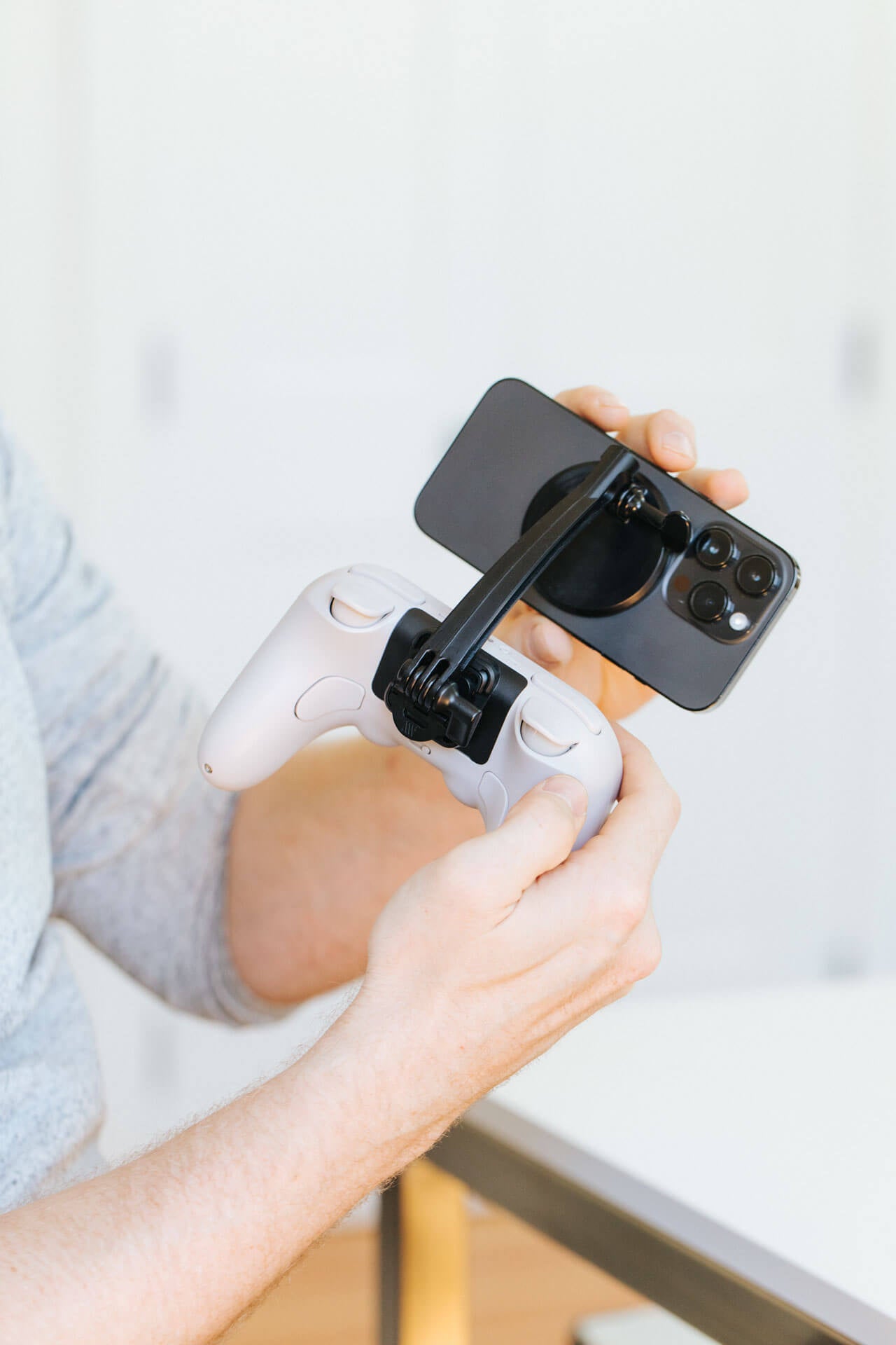 A person attaches a phone to their 8BitDo controller using the Mechanism 8BitDo Grip and Phone Mount