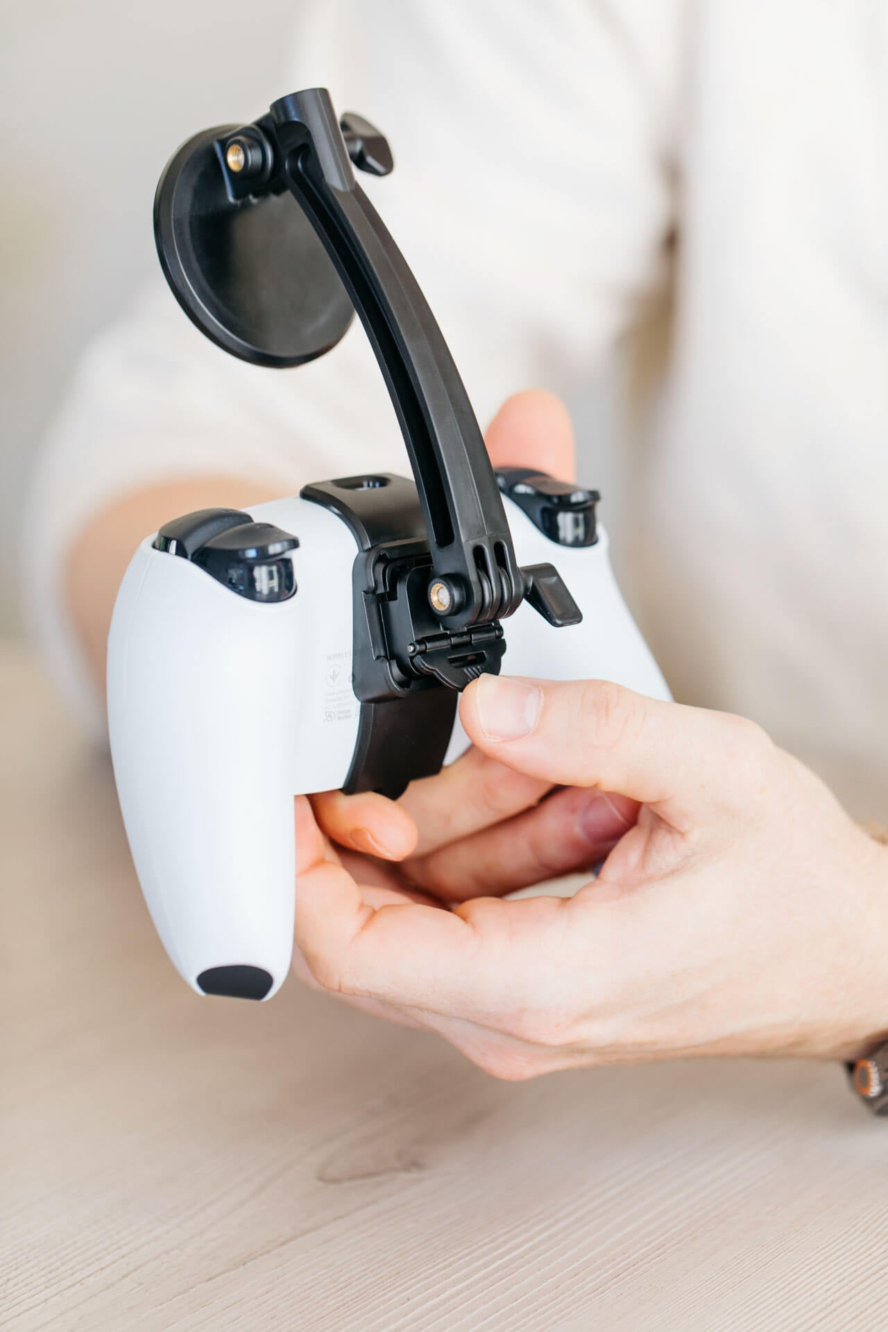 A person attaches a phone to their PS5 controller using the Mechanism PS5 Controller Grip and Phone Mount