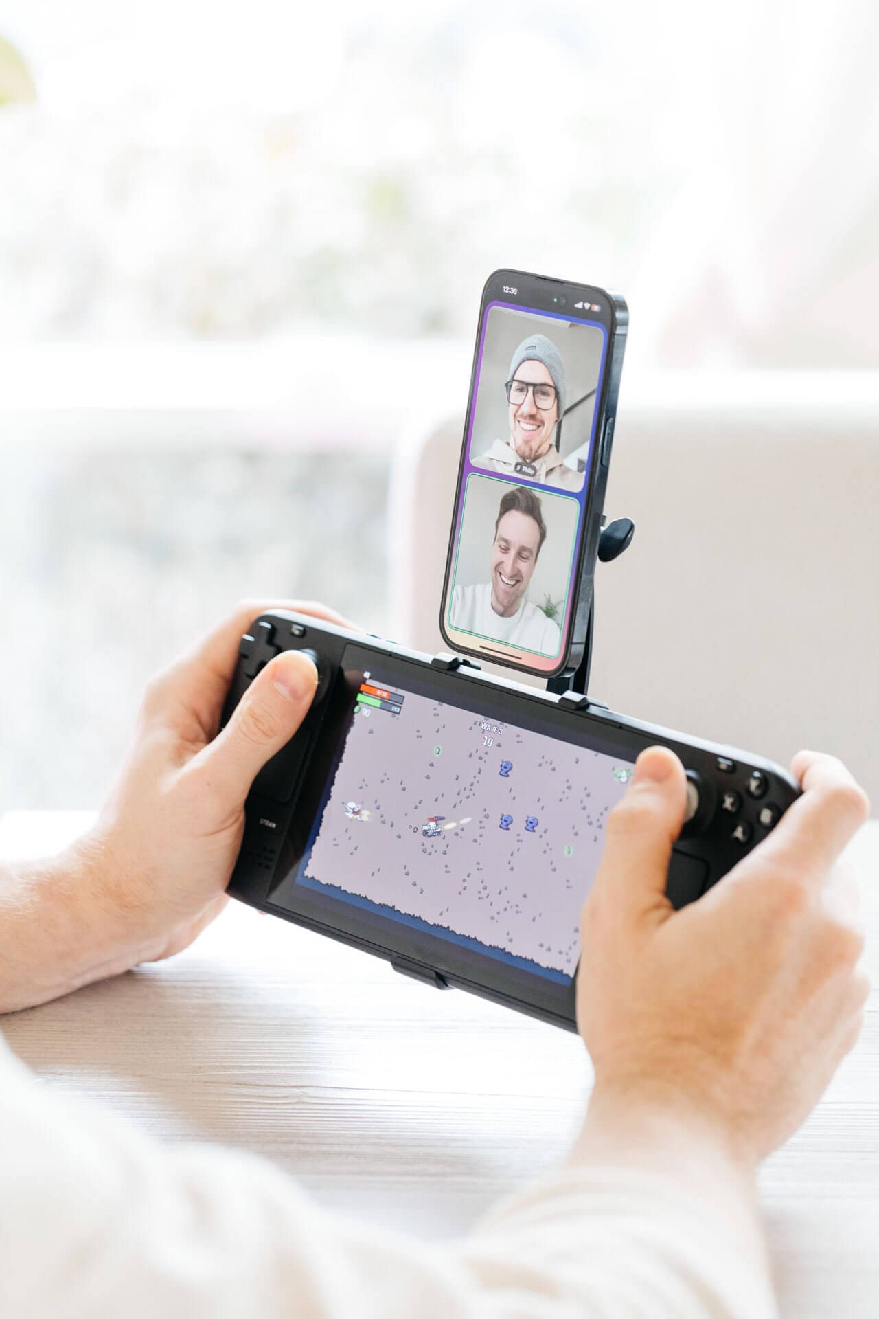 A gamer video calls a friend on discord with his phone mounted vertically above his Steam Deck using the Mechanism Phone Mount.