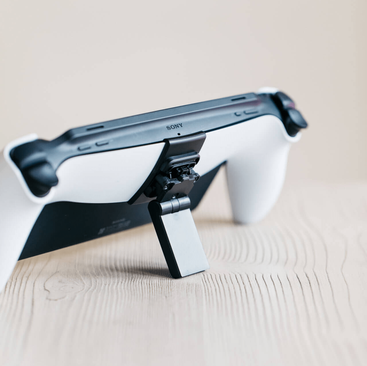 A Playstation Portal propped up on a Mechanism Kickstand using the Portalmate Grip