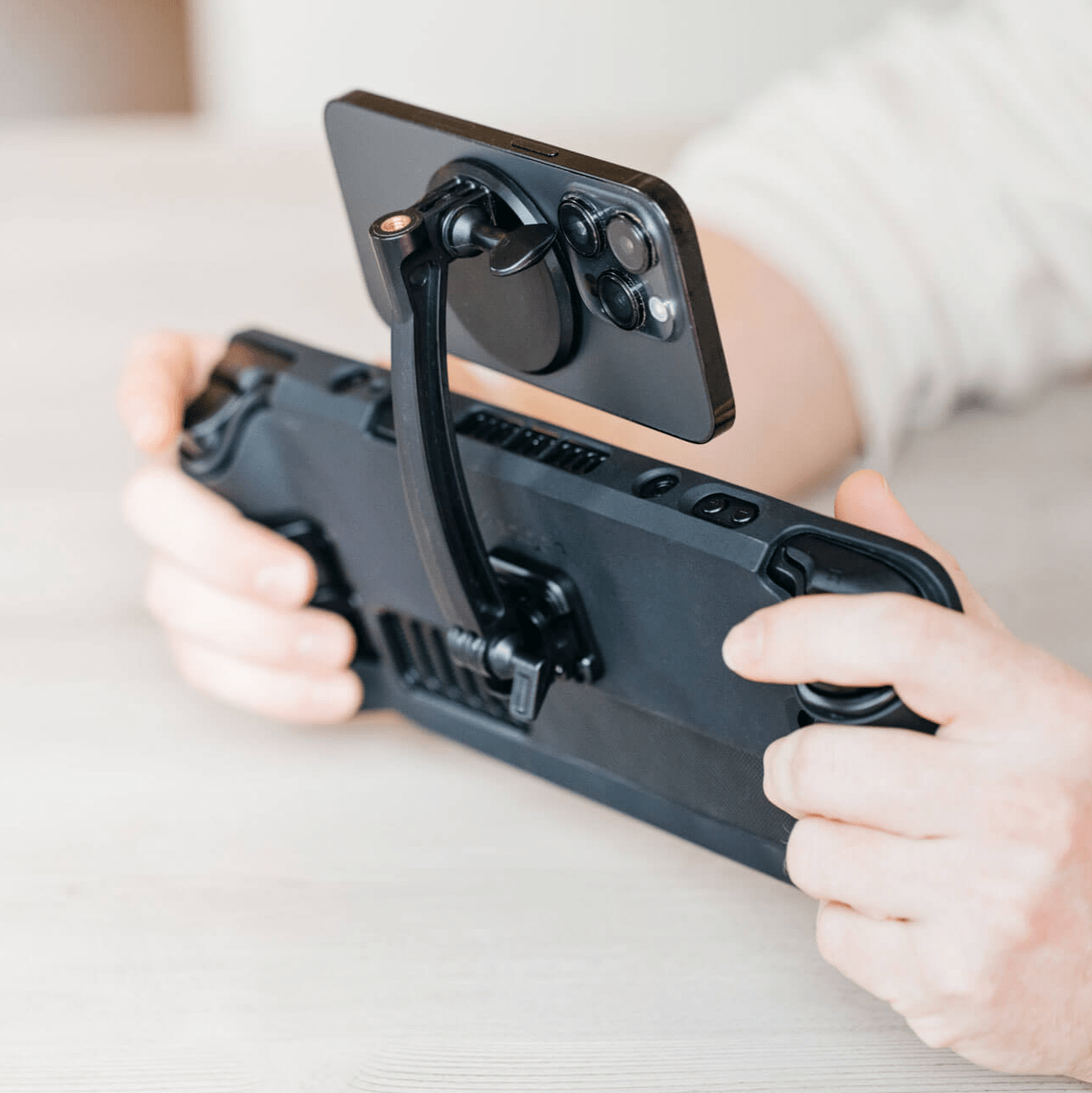 The Mechanism Phone Mount attaches an iPhone below the screen of a Steam Deck