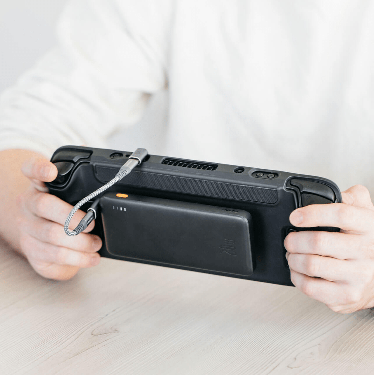 Steam Deck with universal grip on a case and a Battery bank attached with an Adhesive mount