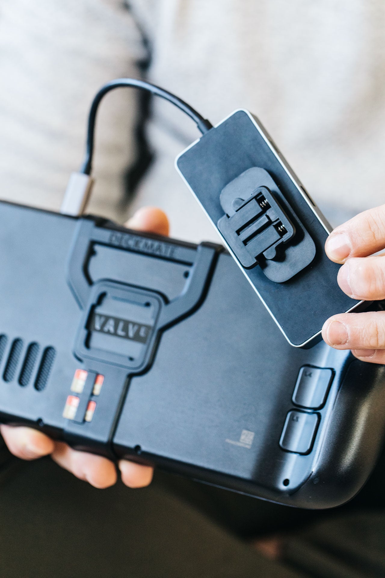 Showing a USB-C hub with a Deckmate Universal Puck attaches to the Deckmate grip on a Steam Deck